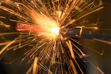 Fototapeta premium Burning sparkler close up on a black background, a lot of sparks