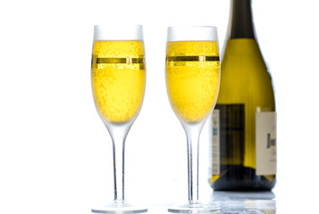 Two glasses with wine, champagne on the background of the bottle