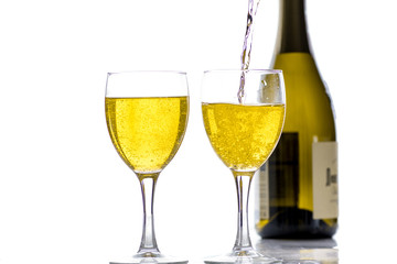 Two glasses with wine, champagne on the background of the bottle