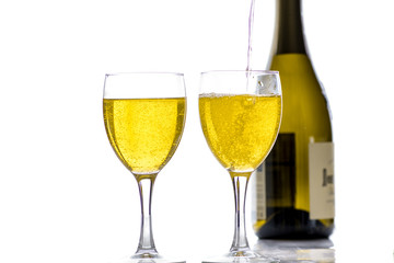 Two glasses with wine, champagne on the background of the bottle