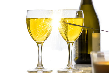 Burning sparkler on the background of glasses of wine, a lot of sparks