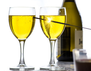 Burning sparkler on the background of glasses of wine, a lot of sparks