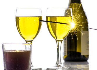 Burning sparkler on the background of glasses of wine, a lot of sparks