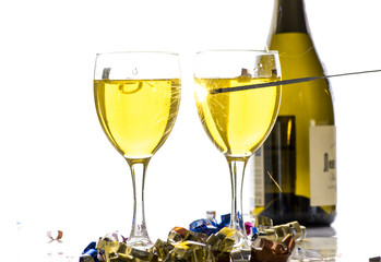 Burning sparkler on the background of glasses of wine, a lot of sparks