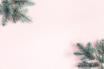 Obraz premium Christmas composition. Frame made of fir tree branches on pastel pink background. Christmas, winter, new year concept. Flat lay, top view, copy space