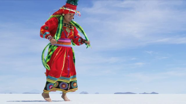 Traditional Bolivian dance performed proudly by Indigenous South American female on Salar de Uyuni Salt flats wearing traditional costume 