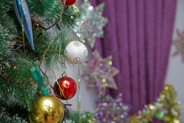 A Christmas ball hangs on the background of a clock. It's time for a new year. Multicolored glare...