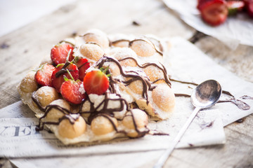 Woman serving sweet waffles with berries and chocolate