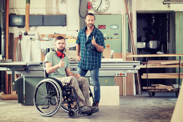 worker in wheelchair in a carpenter's workshop with his colleagu