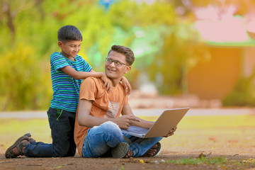 Two Indian brothers working on laptop