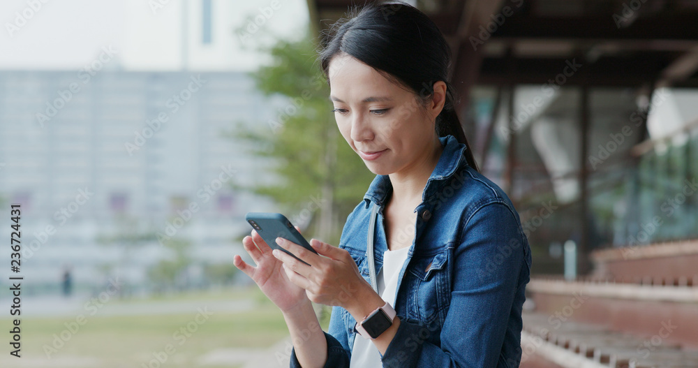 Canvas Prints Woman use of mobile phone and sit on the bench