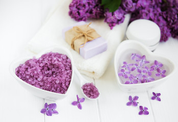 Obraz na płótnie Canvas Spa towel and massage products with lilac flowers