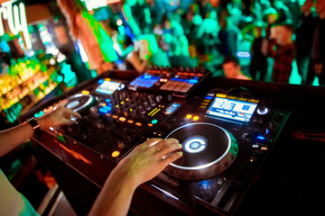 Dj mixes the track in the nightclub at party