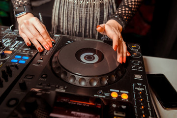 Dj mixes the track in the nightclub at party