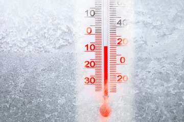 Outdoor thermometer shows minus 7 degrees celsius temperature in cold winter day. Outer thermometer on a frozen window