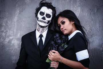 Skull face makeup guy and vampire gothic girl.