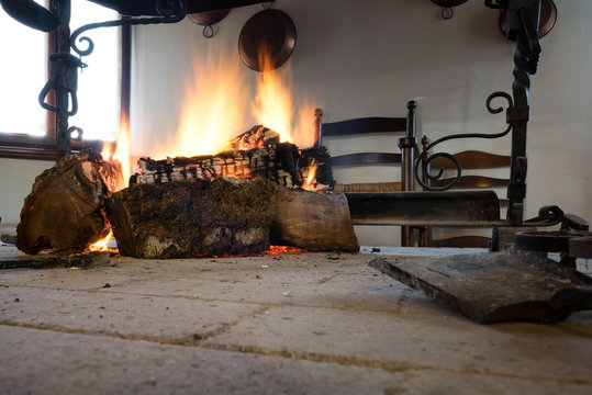 Open fireplace with burning stumps. Kind of fireplace named fogolar typical of Friuli Venezia Giulia Italian region.
