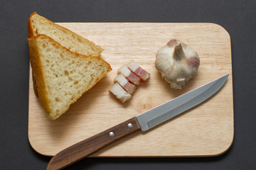 lard with bread and garlic on wooden board