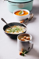 Pea, tomato, vegetable soups and ingredients on concrete background