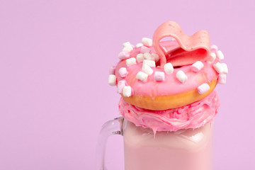 Pink strawberry freakshake with marshmallow and sweets.