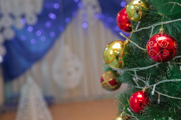 A Christmas red and gold ball hangs on the background of a clock. It's time for a new year. Multicolored glare and brilliance. Gold box