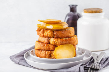 French toast with caramelized pear and syrup on a gray background.