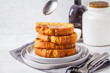 French toast with syrup on a gray plate.