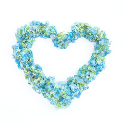 Obraz premium Love symbol of blue hydrangea flowers on white background. Flat lay, top view.