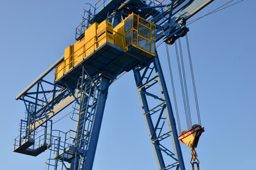 Gantry crane with hook for lifting and moving heavy cruz. Construction site. Industrial plant