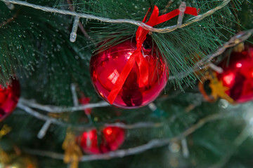 A Christmas red and gold ball hangs on the background of a clock. It's time for a new year....