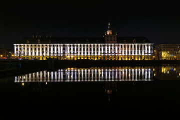 Fototapeta na wymiar Ossolineum Library. With reflection in Odra River at night.