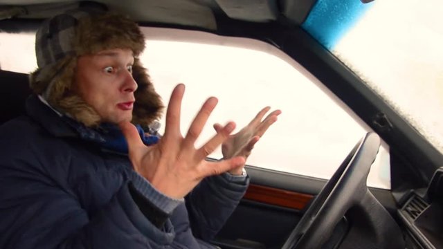 Man in car yells, beats hands on wheel, crazy,