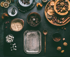 Preparation of homemade vegan chocolate truffle pralines with dried fruits and nuts mix, ingredients on dark background, top view. Healthy sweets. Energy vegan balls with dates, cocoa and almond