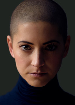 Portrait of a beautiful young woman with short hairstyle. Gorgeous female cancer patient portrait on dark background.