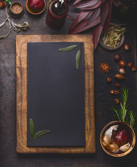Blank chalkboard in wooden frame and cooking ingredients on dark kitchen table background, top view, frame . - obrazy, fototapety, plakaty