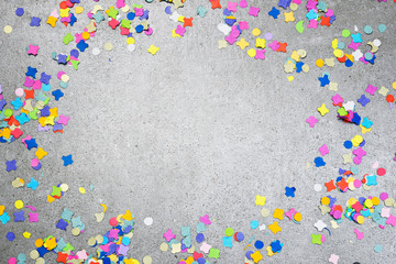 Birthday or holiday background with multicolored confetti on a concrete background. Celebration...