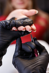 Fototapeta premium manicurist applying gel lacquer coat on client's nails. beauty, make up, manicure, nail art concept