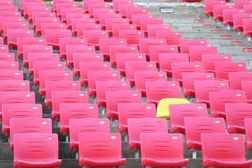 Red seats and one yellow seat stadium background