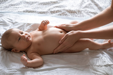 Fototapeta na wymiar Massage stomach for little newborn baby. Mom massaging colic tummy of newborn. Healthy motherhood.