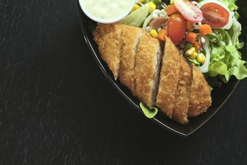Deep fried fish served in a plate with fresh vegetables salad.Menu for good health.