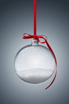 Empty transparent christmas ball over gray background with copy space
