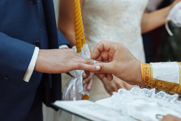 Obraz na płótnie Canvas wedding in the church dressing gold wedding rings shepherd bride and groom