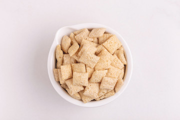 Corn pads in clay bowl on light white background