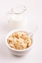 Crispy corn pads in bowl with jar of fresh milk