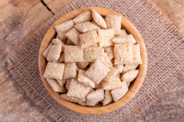 Crispy corn pads in wooden bowl with burlap napkin