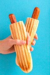 Two grilled french hot dogs in woman's hand