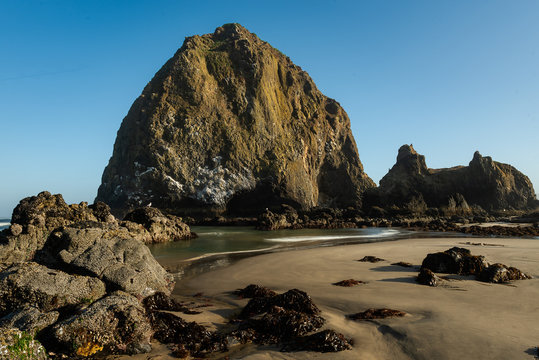 beautiful rocks on cannon beach with soft light and blue sky