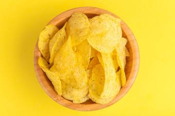 Tasty crunchy potato chips in wooden bowl