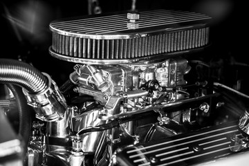 Fragment (air filter and carburetor) of an automobile engine close up. Black and white.