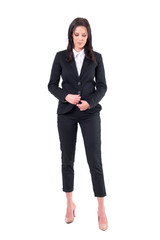 Obraz premium Relaxed young business woman unbuttoning black suit looking down. Full body isolated on white background. 